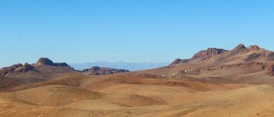 Heat and sand in the foreground, snow-capped mountains in the distance