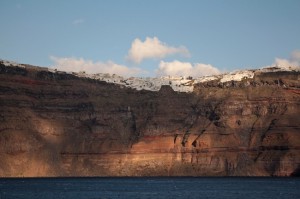 Far above the craters' waters the towns of Santorini perch along its length